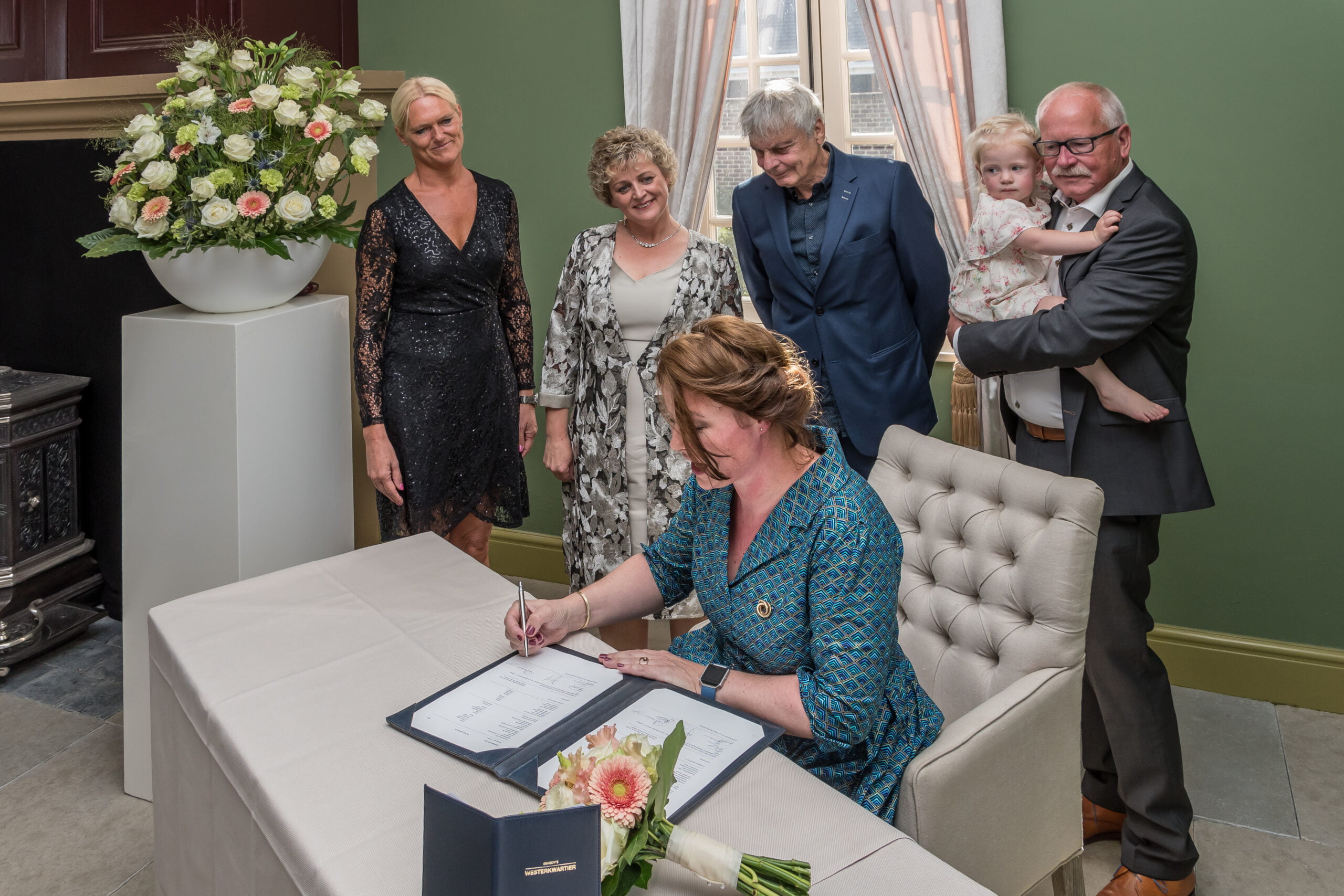 Zelfstandig trouwambtenaar Esther Aalberts-Kalma van Trouw met Liefde tekent de huwelijksakte van de gemeente Westerkwartier